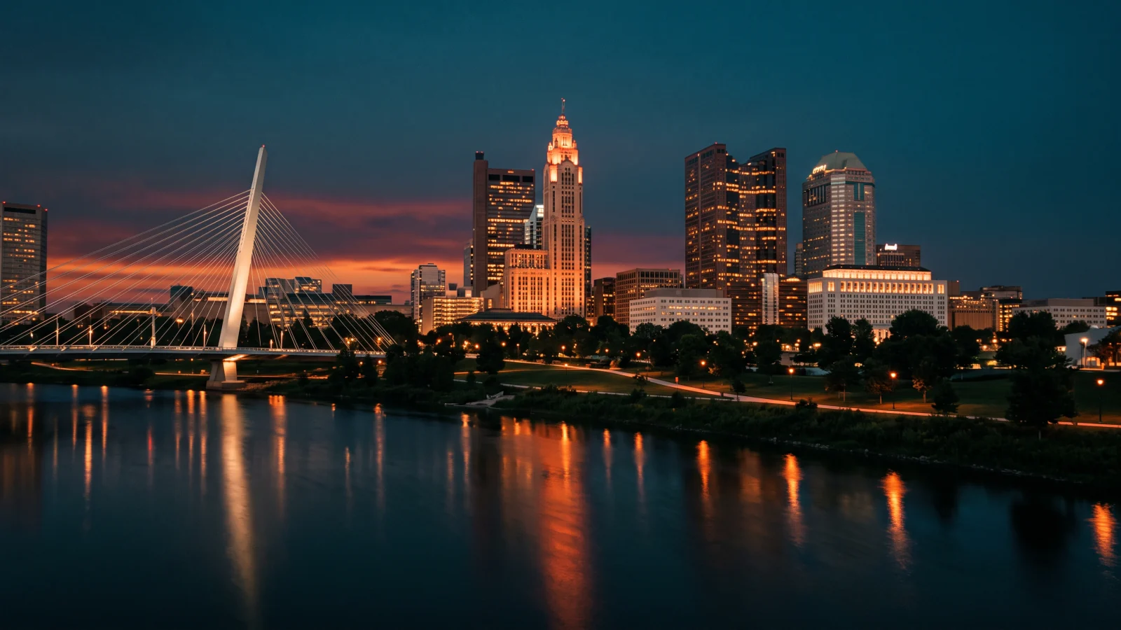Columbus, Ohio downtown skyline at twilight across the Scioto River, the LeVeque Tower glowing beside the Main Street Bridge